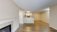 Located at 4725 50th St W in Bradenton, Florida, this single-floor residence offers a well-designed, open layout with a warm and neutral color palette throughout. The spacious living room is a standout, featuring wood-look laminate flooring, a tile-surround fireplace with a white mantle, and a sliding glass door that invites natural light. The living area flows seamlessly into the kitchen zone, which is anchored by a wraparound peninsula with granite-look countertops and a built-in sink. The kitchen itself is efficiently designed in a galley style, outfitted with white cabinetry, stainless steel appliances including a refrigerator, electric range, and dishwasher, and durable laminate flooring. The bedrooms are comfortably appointed with plush carpeting, ceiling fans with lighting, and ample natural light from windows with blinds. The bathroom features a full tub-shower combination with white tile surround and clean, bright finishes. A dedicated laundry area with full-size washer and dryer hookups adds everyday convenience. Textured ceilings and consistent neutral tones throughout lend a cohesive, move-in-ready feel to this practical and comfortable Bradenton residence.