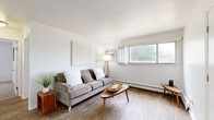 Located at 142 Hillcrest Dr in Fort Collins, Colorado, this well-organized 2-bedroom, 2-bathroom single-floor home offers a thoughtful layout with a clean, understated aesthetic throughout. The living room serves as the heart of the space, featuring warm wood-look flooring, a charming stone fireplace with a rustic wood mantle, and large windows that frame lush, tree-lined outdoor views, filling the room with natural light. A separate area of the living room provides additional seating space, enhancing the functional flow of the home. The kitchen is efficiently designed with warm honey-toned cabinetry, white appliances, and a skylight overhead that brightens the workspace. A convenient pass-through counter connects the kitchen to the adjacent dining area. Both bedrooms are carpeted for comfort, each featuring a sliding-door closet and a window with a view of the surrounding greenery, along with baseboard heating. The primary bedroom offers a spacious and comfortable retreat. The two bathrooms are clean and functional — one features a full tub-shower combination with white tile surround, while the second includes a wood-toned vanity with a white countertop. Wood-look flooring runs consistently through the main living areas, tying the home's design together with a cohesive, neutral palette.