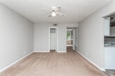 Located at 2106 Waverly Pkwy in Opelika, Alabama, this single-floor unit offers a practical and straightforward layout designed for comfortable everyday living. The living area is carpeted and generously sized, featuring a ceiling fan with light fixture and a textured ceiling. It opens directly to the kitchen, creating an easy flow between the two spaces. A front entry door with a side window brings in natural light, and a mirrored closet door adds a functional storage element nearby.

The kitchen is equipped with white cabinetry, white countertops, a white electric range, a black refrigerator, and a double-basin sink. Wood-look flooring runs throughout the kitchen, providing a durable and easy-to-clean surface that contrasts with the carpeted living and sleeping areas.

The bedrooms are well-proportioned, each featuring soft carpet flooring, neutral-toned walls, and closet access. One bedroom showcases a large multi-pane window with views of the surrounding greenery, allowing ample natural light to fill the room. The other bedroom also benefits from natural light through a side window.

The bathroom includes a single-sink vanity with under-cabinet storage, a wall-mounted mirror, and a tiled tub-shower combination. Wood-look flooring completes the space, maintaining a cohesive aesthetic throughout the unit.