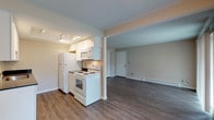 This single-floor unit offers a practical and well-organized layout that connects the main living areas seamlessly. The open-concept living and dining space is finished with durable wood-style laminate flooring and neutral-toned walls, creating a clean and versatile backdrop. A sliding glass door floods the living area with natural light and opens to a private balcony overlooking a green outdoor setting, enhancing the sense of openness. Baseboard heating is present throughout the main living spaces.

The galley-style kitchen is efficiently designed with white cabinetry, dark countertops, a stainless steel sink, and white appliances including a refrigerator, electric range, microwave, and dishwasher. Wood-style flooring continues through the kitchen, maintaining visual consistency.

The bedroom is generously sized and features plush carpeting, neutral walls, and access to a closet. A connecting door leads conveniently to the full bathroom, which includes a vanity with dark countertop, white cabinetry, a tub-shower combination, and wood-style flooring. The overall ambiance of the unit is clean, functional, and move-in ready.