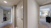 Located at 7950 Village Drive in Cincinnati, OH, this single-floor, 2-bedroom, 2-bathroom home offers a well-organized layout designed for comfortable everyday living. The combined living and dining area forms the heart of the home, featuring plush carpeting, neutral gray tones, crown molding, and large windows that invite natural light. Track lighting accents the dining area, while a sliding glass door leads directly to a private balcony overlooking a lush, wooded landscape — a serene outdoor retreat. The kitchen is outfitted with warm oak cabinetry, granite-look countertops, hardwood-style flooring, and black appliances including a refrigerator, dishwasher, and range. Both bedrooms are carpeted and well-lit by wide windows with views of the surrounding greenery. The spacious primary bedroom offers ample room for large furnishings, while the second bedroom provides a bright, comfortable alternative. Two full bathrooms feature oak vanities, white fixtures, and hardwood-style flooring. A central hallway connects all areas of the home, lined with five closets offering exceptional storage throughout. The private balcony completes this home with peaceful outdoor views of mature trees and open green space.