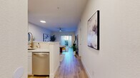 This well-appointed single-floor residence offers five bedrooms and three full bathrooms, thoughtfully designed to maximize functionality and comfort. The open-concept kitchen and living area serves as the heart of the home, featuring white shaker-style cabinetry with gold hardware, quartz countertops, a marble-look tile backsplash, and stainless steel appliances including a range with over-the-range microwave and dishwasher. Light wood-look flooring runs consistently throughout the unit, creating a cohesive and modern aesthetic. The living area is bright and airy, equipped with a ceiling fan and recessed lighting, and opens toward a window that fills the space with natural light. The bedrooms are clean and neutral in tone, each featuring light wood flooring, blinds, and ceiling fans for comfort. The primary bathroom offers a dual-sink vanity with white cabinetry and well-lit mirrors, while secondary bathrooms include a tub-shower combination. Four closets provide generous storage throughout the unit. Two hallways connect the various rooms efficiently, contributing to a smart and functional floor plan. Overall, the space presents a fresh, contemporary feel with clean lines, neutral finishes, and practical design throughout.