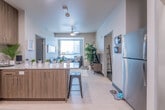 This single-floor unit offers a thoughtfully designed layout well-suited for shared living. The open-concept kitchen flows seamlessly into the living area, featuring warm wood-toned cabinetry, granite countertops with a breakfast bar, and a full suite of stainless steel appliances including a refrigerator, range, microwave, and dishwasher. Recessed lighting and light-toned flooring throughout the kitchen and living areas create a bright, welcoming atmosphere. The living room is anchored by a large window fitted with horizontal blinds that invite natural light, with space for a seating area and media setup. The unit includes multiple bedrooms — both private and shared configurations — each carpeted and furnished with beds, dedicated study desks, and ample room for personalization. Bedrooms feature windows with blinds and private entry doors, providing each resident with a sense of independence. The bathrooms are clean and functional, each offering a full tub and shower combination with a curtain, tile flooring, and towel hardware. Granite vanity countertops are featured in at least one bathroom, adding a polished touch. Overall, the unit presents a modern, practical, and comfortable living environment designed with multiple occupants in mind.