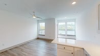 Located at 115 Fourth Ave in Dayton, Kentucky, this single-floor residence offers a clean, modern aesthetic throughout its open and well-designed layout. The living area is bathed in natural light from multiple large windows that frame striking outdoor water views, creating a bright and airy atmosphere. Light-toned luxury vinyl plank flooring flows seamlessly throughout the space, complementing the crisp white walls and adding warmth to the interior. A ceiling fan with integrated lighting provides both style and function in the main living area.

The kitchen is thoughtfully designed with white shaker-style cabinetry, expansive quartz countertops, a tile backsplash, and a full suite of stainless steel appliances, including a range, built-in microwave, dishwasher, and refrigerator. Under-cabinet lighting enhances both ambiance and functionality, while a generous kitchen island offers additional prep and serving space that flows into the living area.

The bathroom features a wide vanity with a quartz countertop, an undermount sink, white cabinetry, and a large wall mirror. Chrome fixtures and wood-look flooring carry the modern design language throughout. The overall layout is efficient and cohesive, making this a well-appointed space with scenic surroundings and contemporary finishes.