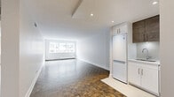 Located on Rue Drummond in the heart of Montréal's prestigious Golden Square Mile neighbourhood, this 2-bedroom, 1-bathroom unit offers a well-organized and functional layout across a single floor. Characteristic parquet flooring in a classic checkerboard pattern runs throughout the unit, lending warmth and a timeless aesthetic to every room.

The living room is generously proportioned, bathed in natural light through large windows that overlook the surrounding urban streetscape. Crisp white walls and clean baseboard trim create a bright, neutral backdrop. A baseboard heating system runs beneath the windows, ensuring comfort year-round.

The primary bedroom is notably spacious, providing ample room for a full bedroom suite. The second bedroom offers a comfortable and versatile space suitable for a variety of uses. A dedicated closet provides practical storage solutions.

A connecting hallway with parquet flooring and clean white panelled doors links the rooms seamlessly, contributing to the unit's cohesive design.

The bathroom stands out as a refined highlight, featuring floor-to-ceiling marble-effect wall tiles, a floating wood-toned vanity with a white countertop and undermount sink, a large mirror, and porcelain tile flooring — a distinctly modern and elegant finish relative to the overall unit.