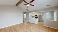 Located at 3422 Cheswick Ct in West Lafayette, Indiana, this 2-bedroom, 1-bathroom single-story home offers a well-designed layout that maximizes every square foot. The open-concept living, dining, and kitchen area is the heart of the home, anchored by striking vaulted ceilings with exposed beams and a ceiling fan that enhance the sense of volume and airiness. A large arched window floods the living space with natural light while offering views of the neighborhood outside. The kitchen features white shaker-style cabinetry, subway tile backsplash, light quartz countertops, a peninsula with pendant lighting, and stainless steel appliances including a refrigerator, range, microwave, and dishwasher. Light hardwood-style flooring runs throughout the main living areas, complementing the neutral gray walls. The primary bedroom includes vaulted ceilings, hardwood-style floors, and an arched window, while the second bedroom offers plush carpeting, a ceiling fan, and a standard window. The full bathroom is clean and bright with a white vanity and a tub-shower combination. The home also includes four closets, a dedicated laundry area, and a utility room, providing practical everyday storage and functionality throughout.