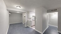 Located at 3400 Garden Oaks Dr in New Orleans, Louisiana, this single-story home offers five bedrooms and two full bathrooms across a well-utilized floor plan. The interior features a consistent neutral gray color palette with crisp white baseboards and textured ceilings throughout, lending the space a clean and cohesive look.

The open living and dining area connects directly to the kitchen, which is outfitted with white cabinetry, upper and lower cabinets, and a stainless steel sink — providing a practical and functional layout. Blue-gray tile flooring runs throughout the common areas and bedrooms, adding a uniform feel to the space.

The primary bedroom is notably generously sized, offering ample room for furnishings and personal use. The remaining four bedrooms are well-proportioned, each featuring neutral gray walls, textured ceilings, and windows that allow natural light to fill the rooms. Two hallways provide efficient circulation between the bedrooms and shared spaces.

Both bathrooms are identically appointed, each featuring a full bathtub and shower combination with beige ceramic tile surround, a toilet, and gray textured walls. The layouts are compact and functional. Overall, this home presents a straightforward, practical living environment suited for larger households in the Garden Oaks neighborhood of New Orleans.