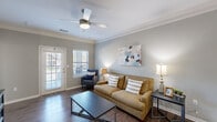 Located at 500 Carlen Ave in Lexington, SC, this well-appointed 2-bedroom, 2-bathroom residence offers a thoughtfully designed single-floor layout. The open-concept living area is finished with rich hardwood-style flooring, crown molding, and a ceiling fan, while large windows and a glass-panel door welcome abundant natural light and outdoor views. The kitchen is a standout feature, boasting granite countertops, dark espresso cabinetry, stainless steel appliances, and a double-basin sink — flowing seamlessly into the adjacent dining area, which is anchored by a pendant light fixture. The primary bedroom is a comfortable retreat with plush carpet, a ceiling fan, and a generous window. The second bedroom mirrors this comfort with its own ceiling fan and natural light. Both bathrooms are well-equipped, with at least one featuring granite countertops, dark wood vanity cabinetry, a large mirror, and a tub-shower combination. A dedicated laundry room accommodates a full-size washer and dryer with built-in shelving for added convenience. Neutral gray tones throughout create a cohesive, modern aesthetic, making this a functional and inviting home.