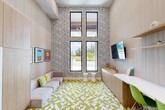 Located in Hialeah, FL, this compact yet visually dynamic room makes a bold design statement from every angle. The space is defined by dramatically tall ceilings that amplify the sense of openness well beyond its modest footprint. A striking black-and-white zigzag patterned wallcovering dominates one full wall, providing a graphic backdrop to the room's energetic aesthetic. Complementing this, the floor is covered in a vibrant green-and-white geometric tile pattern that adds layers of visual interest underfoot.

Natural light floods the interior through a pair of tall, slim black-framed windows stacked vertically on the feature wall, offering views of the outdoors and lending the space an airy, open feel. A built-in wood-toned credenza runs the length of one wall, topped by a mounted flat-screen television and open shelving above — creating a functional and streamlined workstation area complete with modern green accent chairs. A low-profile, tufted gray sofa anchors the lounge side of the room, accented with colorful throw pillows and framed pop-art prints. Black-framed glass double doors connect the room to an adjacent fitness area, enhancing its utility as part of a larger amenity suite.