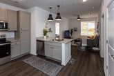 Located at 2230 Chapman Hwy in Knoxville, Tennessee, this single-floor unit offers a clean, contemporary design throughout. The open-concept layout connects the kitchen and living area seamlessly, creating a bright and functional shared space. Large windows allow natural light to flow through the unit, complementing the crisp white walls and warm wood-tone flooring found throughout.

The kitchen is well-appointed with sage-toned shaker cabinetry, granite-style countertops, and a full suite of stainless steel appliances, including a refrigerator, electric range, microwave, and dishwasher. A peninsula with pendant lighting provides additional workspace and casual dining potential. The kitchen opens directly into the living area, which features a ceiling fan and windows with outdoor views, fostering an inviting atmosphere.

Both bedrooms are comfortably sized, each equipped with a ceiling fan and windows that bring in natural light and outdoor scenery. The two bathrooms mirror the kitchen's design aesthetic, with granite-style vanity tops, undermount sinks, and light cabinetry. One bathroom includes a tub-shower combination. A dedicated in-unit laundry area adds everyday convenience to this well-designed Knoxville residence.