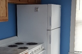 Kitchen with stove, refrigerator and garbage disposal - 127 1/2 S 7th St