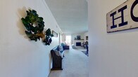 This single-floor, 2-bedroom, 2-bathroom residence offers a thoughtfully designed layout that maximizes functionality and comfort throughout. The combined kitchen and living room serves as the heart of the home, featuring soft carpet flooring in the living area and hard surface flooring in the kitchen. The living room is spacious and welcoming, highlighted by a fireplace, crown molding, and a textured ceiling. A dedicated dining area sits adjacent to a window that draws in natural light, completing the open living space.

The kitchen is equipped with warm wood cabinetry, white countertops, black appliances including a range, microwave, dishwasher, and refrigerator, and offers a practical galley-style layout with a pass-through view into the main living area.

The generously sized primary bedroom features plush carpet, a ceiling fan, crown molding, and sliding glass doors that open directly to an outdoor patio, providing both light and fresh air. The second bedroom is comfortably sized with built-in closet storage and carpet flooring. Both bathrooms are finished with wood vanity cabinetry and light countertops. A hallway connects the bedrooms and bathrooms, providing a clear and efficient flow throughout the home.