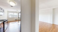 Located at 2175 Hudson Terrace in Fort Lee, NJ, this well-appointed 2-bedroom, 2-bathroom residence offers a thoughtfully designed single-floor layout. Warm hardwood flooring flows throughout the main living areas, creating a bright and cohesive aesthetic complemented by crisp white walls and abundant natural light.

The galley-style kitchen is a standout feature, outfitted with rich dark cabinetry, granite countertops, white subway tile backsplash, and stainless steel appliances including a gas range, microwave, and refrigerator. The kitchen opens toward a welcoming entrance hallway, providing a natural flow through the home. Adjacent to the kitchen, a dedicated dining area connects seamlessly to the expansive living room, which features multiple windows and a door leading to a private patio.

The generously sized primary bedroom offers ample space, a large window with natural light, and access to closet storage. The second bedroom is also well-proportioned with hardwood floors and bright neutral walls. Three closets throughout the unit provide excellent storage capacity.

Both bathrooms are finished with hexagonal tile flooring, dark wood vanities, and granite countertops. One bathroom features a tiled tub-shower combo, while the other offers a glass-enclosed walk-in shower, adding a refined touch to the overall design.