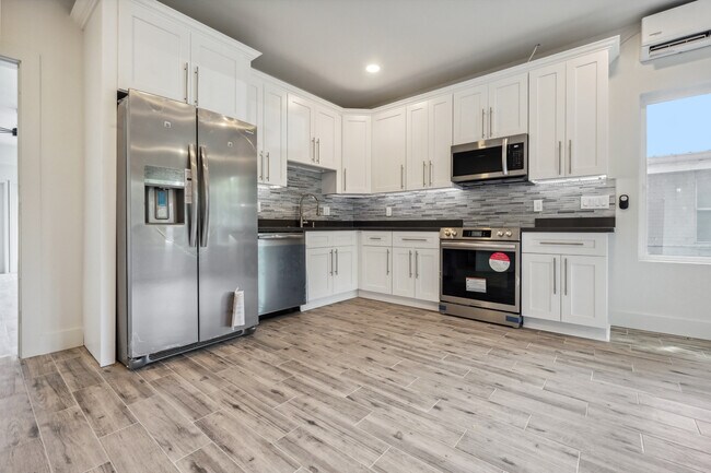 Stainless steel appliances and quartz countertops with custom cabinetry - 428 W Solidelle St