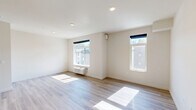 Located at 6020 E Fourth Ave in Spokane Valley, WA, this well-designed 2-bedroom, 2-bathroom unit offers a clean, contemporary aesthetic throughout. The open-concept living and kitchen area is anchored by light wood-style plank flooring, recessed lighting, and large windows that invite abundant natural light. The kitchen is equipped with stainless steel appliances—including a refrigerator, range, microwave, and dishwasher—paired with white cabinetry, a tile backsplash, and track lighting overhead. Both bedrooms are bright and comfortable, each featuring large windows with outdoor views and dedicated closet space. The primary bedroom offers a cozy yet functional layout with its own closet. The two bathrooms are finished in a clean, modern style, with one featuring a full soaking tub and shower combo with chrome fixtures, and the other offering a vanity with a white countertop and large mirror. A notable convenience is the in-unit stacked washer and dryer, neatly tucked behind louvered sliding doors. Neutral wall tones, consistent flooring, and a crisp, minimalist design give the entire space a fresh and move-in-ready feel.