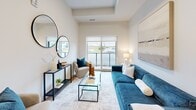 Located at 1002 Niagara St in Welland, Ontario, this thoughtfully designed one-bedroom, one-bathroom unit offers a efficient and modern living experience across a single floor. The open-concept layout maximizes every inch of space, creating a seamless flow between the kitchen, dining area, and living room.

The contemporary kitchen is a standout feature, showcasing tall grey cabinetry, a white subway tile backsplash, stainless steel appliances, and a central island with seating — all illuminated by stylish pendant lighting and light hardwood flooring. The kitchen opens directly into the living area, which benefits from a large sliding glass door that brings in natural light and provides access to an outdoor view of the surrounding area.

The bedroom is a cozy, carpeted retreat featuring a tray ceiling, a large window with an outdoor view, and direct access to a dedicated walk-in closet with built-in shelving. The bathroom is clean and modern, finished with neutral tile flooring, an undermount sink with white cabinetry, and a framed mirror with contemporary vanity lighting.

Throughout the unit, a neutral colour palette, tray ceiling details, and consistent finishes contribute to a cohesive and polished aesthetic that is both functional and inviting.