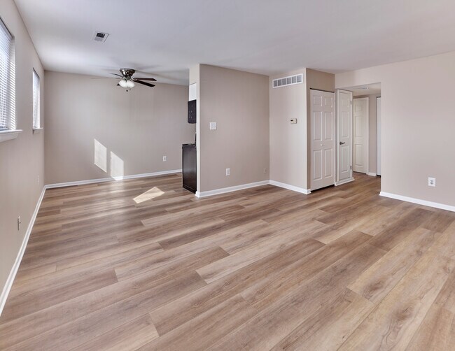 Moderno espacio de estar y comedor de concepto abierto con elegantes pisos de tablones en Village Square. - Village Square