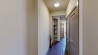 Located in Richardson, TX, this two-story residence offers three bedrooms and three bathrooms across two well-proportioned floors. The main level centers around an open-concept kitchen and living area. The kitchen is outfitted with stainless steel appliances, dark espresso cabinetry, a white quartz countertop island with pendant lighting, a tile backsplash, and hardwood-style flooring, creating a contemporary and functional workspace. Large windows in the living area allow generous natural light and outdoor views.

The upper floor houses the expansive primary suite, one of the most notable features of the home. It includes plush carpeting, a ceiling fan, and direct access to a well-appointed en-suite bathroom featuring dark wood vanity cabinetry, a soaking tub, and tile flooring. A walk-in closet with built-in shelving and dual hanging rods provides ample organized storage. Additional bedrooms are carpeted and include ceiling fans. Secondary bathrooms mirror the primary bath's finishes. Hallways feature hardwood-style flooring, built-in display shelving, and flush-mount lighting, contributing to the home's cohesive, modern aesthetic throughout.