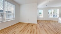 This expansive townhouse in Hartland, WI offers 4,990 square feet of living space across two floors. The unit boasts 2 bedrooms and 2 bathrooms, with the primary bedroom measuring a generous 170 square feet. The ground floor spans 3,720 square feet, while the upper level provides an additional 1,270 square feet.

The interior showcases a modern aesthetic with clean lines and a neutral color palette. Light wood flooring runs throughout most rooms, creating a warm and inviting atmosphere. Large windows with horizontal blinds allow ample natural light to flood the space, enhancing its airy feel.

The kitchen features sleek white cabinetry, stainless steel appliances, and granite countertops. A bathroom reveals a glass-enclosed shower, modern fixtures, and a vanity with ample storage. The bedrooms are spacious and well-lit, with one featuring sliding barn doors for a touch of rustic charm.

The property includes a garage with a concrete floor and an automatic door opener, providing secure parking and additional storage space. High ceilings and recessed lighting contribute to the overall sense of openness and modernity throughout the home.

Located in Unit #206 of Building SF1, this townhouse offers a blend of comfort, style, and convenience in the heart of Hartland, Wisconsin.