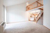 Located at 1020 N High Point Rd in Madison, WI, this two-bedroom, two-bathroom two-story home offers a practical and comfortable layout across two floors. The main level features a combined kitchen and living area, with the kitchen equipped with warm honey-toned oak cabinetry, white appliances including an electric range and refrigerator, a peninsula with a sink, and durable wood-look flooring. A dedicated laundry room with a full-size washer and dryer and overhead shelving is conveniently located just off the kitchen. The living room is carpeted and features a sliding glass door that fills the space with natural light and provides outdoor access. A bathroom on this level includes a wide vanity with a large mirror and Hollywood-style lighting. Upstairs, the expansive primary bedroom is a standout feature, boasting vaulted ceilings with a skylight and a ceiling fan, creating an airy, light-filled retreat. It is complemented by a generously sized walk-in closet with built-in shelving and hanging rods. The second bedroom also offers ample closet space with similar built-in storage. Three closets throughout the home provide exceptional storage capacity, making this a highly functional two-story residence.