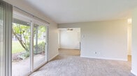 This single-floor, 2-bedroom, 1-bathroom unit offers a functional and comfortable layout designed to maximize everyday living. The combined kitchen and living area forms the heart of the home. The galley-style kitchen is well-equipped, featuring crisp white shaker cabinetry on both sides, light countertops, black appliances including a range, dishwasher, and refrigerator, and light hardwood-style flooring that runs underfoot. A large window at the end of the kitchen fills the space with natural light and offers pleasant outdoor views.

The living room is bright and inviting, with soft carpet underfoot and a sliding glass door that opens to views of lush greenery, bringing the outdoors in. A ceiling fan adds comfort to the space.

Both bedrooms are carpeted and feature baseboard heating. The primary bedroom offers generous proportions with dual closets equipped with built-in shelving and hanging rods, providing ample storage. The second bedroom benefits from a large window overlooking outdoor greenery and includes its own ceiling fan and light hardwood-style flooring.

The bathroom is clean and efficiently designed, featuring a tub-shower combo, a single-sink vanity with white cabinetry, and light wood-style flooring. Neutral tones throughout the unit create a cohesive, move-in-ready aesthetic.