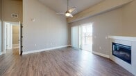 This well-appointed two-bedroom, two-bathroom residence in Colorado Springs, CO offers a thoughtfully designed single-level layout that maximizes comfort and functionality. The open-concept kitchen and living area serves as the heart of the home, showcasing soaring vaulted ceilings, rich dark cabinetry, stainless steel appliances, a subway tile backsplash, and a granite-topped center island illuminated by elegant pendant lighting. The living room extends naturally from the kitchen and features a corner fireplace and a ceiling fan, with sliding glass doors opening to a private balcony with outdoor views. Durable hardwood-style flooring flows throughout the main living areas, adding warmth and continuity. Both bedrooms are carpeted for comfort and equipped with ceiling fans. The spacious primary bedroom includes a closet and an en-suite bathroom featuring dark cabinetry, granite countertops, and a walk-in shower. The secondary bedroom also offers a double-door closet and access to a full bathroom with a tub/shower combo and matching granite vanity. A dedicated laundry room provides added convenience. Neutral tones and clean finishes throughout create a bright, move-in-ready ambiance ideal for modern living.