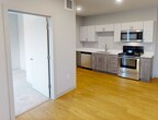 This contemporary 720 square foot apartment in Saint Paul offers a thoughtfully designed living space. The open-concept floor plan combines the kitchen and living room, creating a spacious feel within the compact layout. The kitchen boasts modern amenities, including sleek white cabinets, stainless steel appliances, and a convenient built-in microwave. Natural light floods the living areas through large windows, which also provide urban views.

The bedroom, measuring 130 square feet, features plush carpeting and ample space for a queen-sized bed. A built-in closet offers practical storage solutions. The bathroom is efficiently designed with a combined shower and tub, and includes in-unit laundry facilities with a stacked washer and dryer.

Throughout the apartment, you'll find a cohesive design with neutral tones, recessed lighting, and a mix of hardwood and carpet flooring. The property's single floor layout enhances accessibility and ease of living. Located at 1554 Midway Pkwy in Saint Paul, this apartment combines modern comforts with urban convenience, making it an ideal home for individuals or couples seeking a contemporary living space.