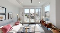 Located at 11311 La Grange in the heart of West Los Angeles, this single-floor unit blends contemporary industrial design with clean, modern finishes throughout. Polished concrete floors and crisp white walls create a cohesive, light-filled aesthetic from entry to end.

A long, open corridor anchors the layout, with exposed silver ductwork running overhead, lending the space an industrial character. The corridor connects the various living zones and features recessed and track lighting throughout.

The kitchen is well-appointed with flat-front white cabinetry, stone-toned countertops, a textured mosaic tile backsplash, and a full suite of stainless steel appliances including a gas range, built-in microwave, and dishwasher.

The living area is a standout, featuring floor-to-ceiling glass doors and large windows that flood the room with natural light and provide direct access to an outdoor space with neighborhood views. A separate dining area sits nearby, bathed in natural light from additional windows and accented by the exposed ductwork above.

The bedroom offers a private retreat with a sliding barn-style door and ample space. The bathroom is finished in white tile, featuring a frameless glass walk-in shower, a floating vanity with an integrated sink, and clean recessed lighting throughout.