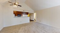 Located at 630 Ondossagon Way in Madison, Wisconsin, this single-floor unit offers a well-designed layout that balances open communal spaces with functional private areas. The living area immediately draws attention with its striking vaulted ceiling, which lends an expansive, airy feel to the space. A ceiling fan with integrated lighting is centrally mounted at the peak, providing both comfort and illumination. Neutral-toned carpet throughout the living area creates a warm, cohesive atmosphere.

The kitchen is positioned adjacent to the living area and is separated by a breakfast bar topped with granite-patterned countertops. Warm wood-toned cabinetry, black appliances including a refrigerator and microwave, and wood-look tile flooring give the kitchen a practical yet polished appearance. A pass-through design between the kitchen and living space enhances the open-concept flow.

The bedroom features its own ceiling fan, plush carpeting, and a sliding glass door that opens to a private outdoor balcony overlooking lush greenery, offering a peaceful outdoor retreat with natural light.

The bathroom includes rich wood-toned cabinetry topped with granite-style countertops, a large vanity mirror with overhead lighting, a tiled shower, and a separate soaking tub, all finished with wood-look tile flooring for a clean, cohesive look.