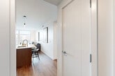 Located at 707 South Worth Street in Birmingham, MI, this contemporary one-bedroom, one-bathroom residence offers a thoughtfully designed layout with modern finishes throughout. Warm hardwood flooring flows seamlessly across the entire space, unifying each room with a cohesive aesthetic.

The open-concept kitchen and living area serves as the heart of the home. The kitchen is outfitted with sleek two-tone cabinetry in gray and taupe, stainless steel appliances, a built-in microwave, and a generously sized island with a white quartz countertop and bar seating — ideal for both meal prep and casual dining. A linear pendant light adds a sophisticated touch overhead.

The living room is bathed in natural light from large floor-to-ceiling windows and a glass door that opens to an outdoor view of the Birmingham streetscape. The bright, airy atmosphere is complemented by clean white walls and recessed lighting.

The spacious primary bedroom also benefits from expansive floor-to-ceiling windows, flooding the room with sunlight and offering open urban views. The hallway connects the bedroom to the well-appointed bathroom, which features a frameless glass walk-in shower with large-format tile, a wood-toned vanity, and a sleek oversized mirror.

A dedicated laundry area houses a full-size Whirlpool washer and dryer beneath a countertop with ample overhead cabinetry and open shelving, rounding out this efficient and stylish residence.