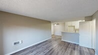 Located at 2600 S Azusa Ave in West Covina, California, this 3-bedroom, 1-bathroom residence offers a practical and well-appointed single-floor layout. The open living and dining area features wood-style plank flooring, neutral warm-toned walls, a textured ceiling, and a ceiling fan, creating a comfortable and inviting atmosphere. The kitchen is thoughtfully designed with crisp white cabinetry, a sparkling quartz countertop peninsula with an integrated stainless steel sink, a black electric range, and a dishwasher — combining style and function seamlessly.

The three bedrooms are carpeted for comfort, each featuring neutral tones and windows that allow natural light to filter in. One bedroom offers a pleasant outdoor view of a communal playground area. Each bedroom includes a closet with sliding or hinged doors, providing ample storage. The spacious primary bedroom connects conveniently to the bathroom area and features a dedicated vanity space with white cabinetry.

The full bathroom is finished in a clean, bright white palette, featuring a wide vanity with under-cabinet storage, a large mirror with contemporary lighting, and a shower-tub combination. Wood-style flooring continues throughout the bathroom, tying the space together cohesively. A dedicated entrance and closet round out this well-organized home.