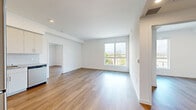Located at 18900 Parthenia St in the Northridge neighborhood of Los Angeles, this modern 2-bedroom, 2-bathroom residence offers a clean, contemporary design throughout. Wood-style plank flooring runs continuously across the living areas and bedrooms, complementing the crisp white walls and creating a warm, cohesive aesthetic.

The open-concept kitchen and living area serves as the heart of the home. The kitchen is outfitted with stainless steel appliances — including a full-size refrigerator, range, microwave, and dishwasher — paired with white cabinetry, granite-style countertops, and a white tile backsplash. Recessed lighting adds a polished finish to the space.

Both bedrooms are bright and well-proportioned, each featuring large windows that invite natural light and offer views of the surrounding neighborhood. The primary bedroom includes dedicated closet space, while the second bedroom features sliding closet doors for convenient storage.

The two bathrooms are finished with large-format light tile flooring and marble-look tiled tub-shower surrounds, creating a clean, spa-like atmosphere. Each bathroom includes a vanity with granite-style countertops and modern chrome fixtures.

The overall ambiance of this residence is bright, modern, and move-in ready, reflecting thoughtful design choices throughout.