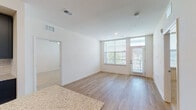 Located near I-435 N in Lenexa, Kansas, this single-floor residence offers a clean, contemporary design throughout. The open-concept living area is finished with light wood flooring and crisp white walls, creating a bright and airy atmosphere. Large windows fitted with blinds allow generous natural light to fill the space, and a private exterior door provides direct outdoor access.

The kitchen is a standout feature, showcasing bold slate-blue shaker-style cabinetry paired with granite countertops, a classic white subway tile backsplash, and a full suite of stainless steel appliances. A kitchen island with an integrated sink adds both functionality and a focal point to the space.

The bedrooms are finished with plush neutral carpet and ceiling fans, offering a comfortable retreat. Each room includes ample wall space and good natural light from well-placed windows. A dedicated bedroom connects directly to a bathroom, which features dark vanity cabinetry with granite countertops, a backlit vanity mirror, light wood-style flooring, and a glass-enclosed walk-in shower — delivering a polished, modern aesthetic. The overall design balances contemporary finishes with a welcoming, functional layout throughout.