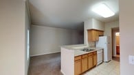 Located at 4500 Highway 57 in Ocean Springs, Mississippi, this single-floor unit offers a well-designed, functional layout with a warm, neutral color palette throughout. The open-concept kitchen flows seamlessly into the living area, creating a connected and spacious feel. The kitchen is equipped with warm-toned oak cabinetry, granite-style countertops, a double-basin sink, white appliances including a refrigerator and dishwasher, and light tile flooring. A peninsula counter provides additional workspace and visual separation from the carpeted living area, which features crown molding for a refined touch.

The bedrooms are generously sized, each with plush carpeting, ceiling fans with light fixtures, and windows with blinds that allow natural light to filter in. At least one bedroom includes a walk-in closet with built-in shelving, offering practical storage. The remaining bedrooms are equally comfortable and versatile.

Two full bathrooms mirror each other in design, each featuring tile flooring, a tub-shower combo with white tile surround, a granite-topped vanity with oak cabinetry, a large mirror, overhead lighting, and an overhead storage cabinet. The consistent finishes and neutral tones throughout the unit create a cohesive and move-in-ready living environment.