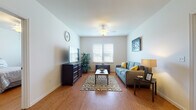 This single-floor residence at 4750 English Ave. in Fort Meade, Maryland offers a thoughtfully designed layout that balances comfort and functionality throughout. Warm hardwood flooring runs consistently through the main living areas, contributing to a cohesive and inviting atmosphere.

The living room serves as the central gathering space, featuring a ceiling fan, neutral walls, and dual windows that invite natural light and outdoor views. Six-panel interior doors and clean trim details reflect a consistent, classic design sensibility throughout the home.

The kitchen is equipped with light wood cabinetry, black appliances, and a white breakfast bar with seating for two, providing a casual dining option that connects seamlessly to the living area. A dedicated laundry room houses a full-size washer and dryer, adding practical convenience.

The bedrooms are comfortably sized with hardwood floors and natural light from well-positioned windows. One bedroom includes a built-in desk, making it well-suited as a functional workspace. The bathrooms feature tile flooring, light wood vanity cabinetry, and a shower-tub combination, offering a clean and efficient design. Overall, the space presents a well-maintained, functional floor plan suited for everyday living.