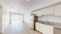 Located in Phoenix, AZ, this single-story residence offers 2 bedrooms and 3 bathrooms with a clean, contemporary design throughout. Light wood-look flooring runs continuously across the entire floor plan, creating a cohesive and airy feel.

The open-concept kitchen is outfitted with white flat-panel cabinetry, granite-style countertops, and stainless steel appliances including a refrigerator, range, microwave, and dishwasher. Recessed lighting illuminates the space, which flows seamlessly into the living area. The living room benefits from abundant natural light through a large sliding glass door that opens to an outdoor area, complemented by a ceiling fan overhead.

The primary bedroom is a well-proportioned retreat featuring a ceiling fan, a window with outdoor views, and direct access to a dedicated bathroom and a closet with built-in shelving. The bathrooms maintain the home's modern aesthetic with granite-topped vanities, light wood cabinetry, large mirrors, and wood-look flooring. One bathroom includes a combined tub and shower, while another features a private water closet.

The second bedroom is bright and spacious with neutral white walls and consistent flooring. A hallway connects the rooms efficiently. The overall palette — crisp white walls, light floors, and brushed metal fixtures — gives the home a clean, move-in-ready appeal.