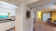 This two-floor, two-bedroom, one-and-a-half-bathroom home offers a thoughtfully arranged layout with distinct living spaces across its generous footprint. The living room serves as the heart of the home, featuring plush carpeting, a bold navy accent wall, and a sliding glass door that fills the space with natural light. A cozy dining nook adjacent to the living area provides an intimate setting for meals. The kitchen is efficiently designed with white cabinetry, dark speckled countertops, a stainless steel sink, and a gas range. Both bedrooms are carpeted and well-proportioned, each offering a calm, neutral palette with ample wall space and windows that bring in natural light. One bedroom features a mirrored closet door, adding depth to the room. The full bathroom includes a tub-shower combination with a stylish curtain, white vanity cabinetry, and matching dark speckled countertops consistent with the kitchen's finish. Textured ceilings are present throughout the home, adding a classic residential character. The overall layout transitions smoothly between living, dining, and sleeping areas, creating a cohesive and functional living environment suited for everyday comfort.