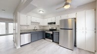 Located at 120 Hayes St in Delaware, Ohio, this two-story home offers a well-organized layout spread across two floors of nearly equal size. The main level includes an entrance, a stylish kitchen, and a living area. The kitchen is a standout feature, showcasing two-tone cabinetry with white upper cabinets and slate-gray lower cabinets, granite-style countertops, a subway tile backsplash, and a full suite of stainless steel appliances including a refrigerator, range, over-range microwave, and dishwasher. Light wood-style flooring and a ceiling fan complete the kitchen's modern aesthetic. The living area benefits from natural light through French doors that open to the outside. Upstairs, two carpeted bedrooms provide a comfortable retreat, each with windows that allow natural light. The spacious primary bedroom offers generous square footage, while the second bedroom includes a sliding-door closet with built-in rod storage. Both bathrooms are finished cleanly in white, with light wood-style tile flooring and tub-shower combinations. Neutral gray walls, textured ceilings, and consistent finishes throughout lend the home a cohesive and move-in-ready appearance.