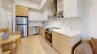 Located at 2826 Jacklin Rd in Victoria, BC, this thoughtfully designed three-bedroom, two-bathroom unit offers a clean, contemporary aesthetic throughout. Light hardwood flooring flows seamlessly across the single level, complementing the bright white walls and recessed lighting found in every room.

The open-concept living, dining, and kitchen area serves as the heart of the unit. The kitchen is well-appointed with two-tone cabinetry in warm wood and white, stainless steel appliances including a refrigerator, dishwasher, and range, a sleek stainless range hood, and a striking marble-style quartz backsplash with matching countertops.

The primary bedroom offers a comfortable footprint with access to a dedicated walk-in closet fitted with hanging rods. A second bedroom features a window with scenic views of the surrounding hillside and greenery, while a third bedroom showcases an exposed concrete accent wall, adding an industrial touch. In-unit stacked laundry is conveniently accessible from the bedroom hallway.

Both bathrooms are finished to a high standard, with one featuring a floating wood-toned vanity and a full marble-tiled tub and shower enclosure with sliding glass doors. A private balcony and a well-lit hallway connecting all rooms round out this efficiently planned and modern unit.