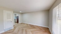 Located at 6200 Colonel Glenn Rd in Little Rock, Arkansas, this one-bedroom, one-bathroom residence offers a thoughtfully designed single-floor layout. The living room is a standout space, featuring striking herringbone-patterned hardwood floors and neutral-toned walls that create a clean, modern aesthetic. A large window floods the room with natural light and provides views of surrounding greenery, enhancing the open and airy feel of the space. The front entry door opens directly into this welcoming area, making for a smooth and functional flow throughout the unit. The galley-style kitchen is efficiently arranged, featuring stainless steel appliances including a refrigerator and gas range, light cabinetry, and the same herringbone hardwood flooring that carries through from the living area. A louvered door adds a charming, classic touch to the kitchen entrance. The bedroom is a comfortable and well-proportioned retreat, with light hardwood floors, soft neutral walls, and two doors offering closet access. A window provides natural light and ventilation. The hallway connects the rooms seamlessly, maintaining a consistent and cohesive design palette. The bathroom is finished with clean white tile wainscoting, a tub-shower combination, and essential fixtures, maintaining a simple and functional character throughout.