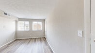 Located at 810 Lasalle Ave in Hampton, Virginia, this single-floor home presents a clean, modern aesthetic with thoughtful updates throughout. Light wood-look flooring runs consistently across the living spaces, complementing the neutral warm-gray wall tones and bright white trim that create a cohesive, airy feel.

The kitchen is a standout feature, outfitted with crisp white shaker-style cabinetry, light quartz countertops, and a full suite of stainless steel appliances including an electric range, over-the-range microwave, dishwasher, and refrigerator. A double-basin stainless steel sink with a modern pull-down faucet anchors the workspace.

The bedrooms are generously proportioned, each benefiting from natural light through horizontal-blind-fitted windows that offer views of the surrounding neighborhood. One bedroom includes a built-in closet with ample storage space. The textured ceilings add subtle architectural character to the rooms.

The bathroom is neatly appointed with a full tub-shower combo, white vanity, and chrome fixtures, all finished with matching light hardwood flooring for a consistent look. The overall layout, as visible in the overhead dollhouse view, flows efficiently between the living, kitchen, bedroom, and bathroom areas, making this a well-organized and move-in-ready home.