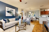 This single-story residence in Birmingham, Alabama offers a thoughtfully designed layout across two bedrooms and two full bathrooms. The living room serves as the heart of the home, featuring warm hardwood-style flooring, crown molding, and a ceiling fan. A bold blue accent wall anchors the space, complemented by large windows and a glass-paned door that invite abundant natural light and outdoor views. The open flow connects seamlessly to the kitchen, which is outfitted with rich cherry-toned cabinetry, granite countertops, a subway tile backsplash, stainless steel appliances, and a peninsula that doubles as a breakfast bar. Crown molding and pendant lighting add refined touches throughout.

Both bedrooms continue the blue accent wall motif and are fitted with ceiling fans, ample natural light from blinded windows, and plush carpeting. Each bathroom features a granite-topped vanity with rich wood cabinetry, a framed mirror, and stylish fixtures. The cohesive color palette of steel blue, warm wood tones, and neutral grays gives the entire residence a polished, contemporary aesthetic with an inviting, residential warmth.