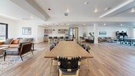 This expansive amenity floor in Cheyenne, Wyoming offers a thoughtfully designed collection of community spaces to accommodate a variety of lifestyle needs. The club room serves as the social centerpiece, featuring warm wood-look flooring, a fireplace with tile surround, large communal dining and seating areas, wall-mounted TVs, and French doors that welcome abundant natural light and outdoor views. A lounge area with a stylish media console and oversized windows adds to the inviting atmosphere.

The fitness center is well-appointed with a full suite of cardio equipment — including treadmills, ellipticals, stationary bikes, and a rowing machine — positioned in front of expansive floor-to-ceiling windows. A dedicated strength training area features free weights, weight racks, cable machines, and mirrored walls, all set against bold, energetic accent walls with geometric graphics.

The yoga room provides a serene, open space with tile flooring and large windows offering peaceful outdoor views — ideal for stretching, meditation, or group classes. The kids center includes a wall-mounted TV, child-sized furniture, colorful play elements, and patterned carpet tiles, creating a fun and safe environment. Classic arcade machines in a dedicated lounge area round out the entertainment offerings.