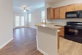 Located at 526 Dill Ln in Murfreesboro, Tennessee, this single-story home offers a thoughtfully designed layout with a clean, neutral aesthetic throughout. The open-concept living and dining area is finished with warm hardwood-style flooring and crown molding, and is illuminated by natural light streaming through blinds-fitted windows. A ceiling fan adds both style and function to the space. French doors lead to the exterior, further enhancing the sense of openness.

The kitchen is equipped with warm honey-toned cabinetry, a built-in wine rack, granite-style countertops, and black appliances including a range, microwave, and refrigerator. A peninsula with a sink and breakfast bar connects the kitchen to the living area, creating an ideal space for casual dining or entertaining.

The bedrooms are carpeted for comfort and feature generous natural light through large windows with blinds. The layout provides a clear separation between living and sleeping areas, as seen in the floorplan overview.

The bathroom includes a full tub and shower combination with tiled surround, brushed nickel fixtures, and hardwood-style flooring, offering a clean and functional space. Throughout the home, consistent use of neutral tones, white trim, and quality finishes creates a cohesive and inviting atmosphere.