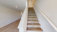 Located at 101 N 7th Ave in Cornelius, Oregon, this two-bedroom, two-bathroom unit is thoughtfully laid out across two floors of nearly equal size. The main floor features an open-concept kitchen and living area, where the kitchen stands out with crisp white shaker cabinets, marble-style quartz countertops, a subway tile backsplash, a central island, and a full suite of stainless steel appliances including a range, microwave, dishwasher, and refrigerator. Light hardwood-style flooring runs throughout the main level, contributing to a bright and airy atmosphere. A utility room and hallway complete the first floor layout. Upstairs, two carpeted bedrooms offer a comfortable retreat, each featuring ceiling fans and windows that bring in natural light. The primary bedroom includes a closet and connects to the upper hallway. Both bathrooms are finished with marble-style countertops, tile flooring, and full tub-shower combinations with chrome fixtures. A half-bath on the upper level provides additional convenience. The overall aesthetic is clean and modern, with a neutral color palette and consistent finishes that create a cohesive, move-in ready feel throughout the home.