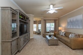 Located at 2104 Grandeur Dr in Salisbury, NC, this single-story home offers a thoughtfully designed layout with a cohesive, neutral aesthetic throughout. The living room sets a welcoming tone with warm beige walls, plush carpeting, and crown molding, complemented by natural light filtering through the windows. A built-in entertainment wall unit with display cabinetry serves as a standout focal point, adding character to the space.

The kitchen features warm wood cabinetry, granite countertops, tile flooring, and black appliances, including a range, microwave, and refrigerator. Adjacent to the kitchen, a dedicated dining area showcases wainscoting, crown molding, and tile flooring, creating a polished, intimate setting for meals.

The primary bedroom is generously sized with soft carpeting, a ceiling fan, and ample natural light. It connects to a spacious walk-in closet outfitted with extensive wire shelving and hanging rods. A secondary bathroom includes a vanity with granite countertops and warm wood cabinetry.

A dedicated laundry area houses a full-size washer and dryer beneath upper wood cabinets, providing practical storage. Overall, the home presents a comfortable, well-organized living environment with consistent finishes throughout.