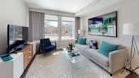Located at 222 M St SW in Washington, DC, this single-floor residence offers a thoughtfully designed layout that balances modern aesthetics with functional living. The open-concept floor plan connects the kitchen, dining, and living areas, creating a cohesive and inviting space throughout.

The kitchen is outfitted with stainless steel appliances, including a gas range, microwave, dishwasher, and refrigerator. Light wood cabinetry lines the walls, complemented by clean white countertops and a central island with bar seating—ideal for casual dining or entertaining. Track lighting overhead adds a contemporary touch while providing ample illumination.

The living area is bright and welcoming, featuring large windows that frame outdoor views of the surrounding neighborhood and invite generous natural light. The neutral color palette, hardwood-style flooring, and well-proportioned layout make the space versatile and comfortable.

The bedroom is a serene retreat, offering a similarly generous window with views of the outdoors, soft carpeting, and neutral tones that create a calm atmosphere. A gallery-style wall arrangement above the bed adds visual character to the room.

The bathroom is finished with large-format white tile flooring, a frameless glass walk-in shower, a floating vanity with ample storage, and recessed lighting, giving the space a clean, spa-like quality throughout.
