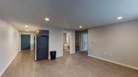 Located at 2220 SE 192nd Ave in Vancouver, Washington, this single-floor unit offers a thoughtfully designed layout with contemporary finishes throughout. The kitchen is equipped with dark espresso cabinetry extending to the ceiling, stainless steel appliances including a gas range, microwave, and refrigerator, as well as a double-basin sink framed by a white quartz countertop and a classic subway tile backsplash. A bold teal entry door adds a distinctive design accent.

The open living area features warm luxury vinyl plank flooring, recessed lighting, and a neutral gray color palette that creates a clean, modern atmosphere. A wall-mounted thermostat provides convenient climate control. The space connects directly to an accessible bathroom fitted with a wall-mounted sink, illuminated mirror, grab bar, and a toilet, designed to accommodate a range of accessibility needs.

Additional rooms include private bedrooms carpeted in warm tones, each with windows dressed in white blinds that allow natural light to filter in. One room features a wall-mounted HVAC unit for individual climate control. The hallway bathroom area offers additional accessibility features. Overall, the unit presents a well-organized and functional floor plan suited for comfortable everyday living.