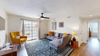Located at 1825 E Republic Rd in Springfield, MO, this single-floor, 2-bedroom, 2-bathroom residence offers a thoughtfully designed layout that maximizes every square foot. Wood-look flooring flows consistently throughout, tying the space together with a warm, cohesive aesthetic.

The living room serves as the heart of the home, featuring a ceiling fan, sliding glass doors that open to a private balcony, and an abundance of natural light. The galley-style kitchen is well-appointed with white shaker cabinetry, light countertops, stainless steel appliances including a refrigerator, range, and microwave, and a deep undermount sink — a clean, functional space for everyday cooking.

Both bedrooms are comfortably sized with ceiling fans, large windows that invite natural light, and wood-look flooring. The primary bedroom offers ample room and connects to one of the two bathrooms, which features a white vanity and a shower-tub combination with a decorative curtain. The second bathroom mirrors the clean, modern aesthetic with a white vanity and updated fixtures.

The overall design balances practicality with a contemporary mid-century modern style, reflected in the clean lines, neutral palette, and warm accent tones found throughout the space.
