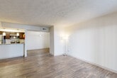 Located at 8601 Roberts Dr in Sandy Springs, GA, this two-bedroom, two-bathroom single-floor residence offers a well-organized layout designed for comfortable everyday living. The living area is bright and open, featuring durable wood-style flooring and a textured ceiling, with a sliding glass door providing direct access to an outdoor patio and allowing natural light to fill the space. The layout flows seamlessly into a dining area and galley-style kitchen, which is equipped with dark espresso cabinetry, granite countertops, stainless steel appliances including a refrigerator, dishwasher, microwave, and electric range, plus pendant lighting that adds a polished touch. Both bathrooms echo the kitchen's aesthetic with matching granite countertops and dark wood vanities. The primary bathroom features a tub-shower combination with tile surround, while the second bathroom also includes a full tub and shower. The two bedrooms are carpeted for comfort and each includes a window with natural outdoor views and a dedicated closet. Two hallways provide convenient circulation throughout the home. The overall ambiance is clean, neutral, and move-in ready, presenting a practical and cohesive design throughout.